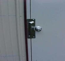 Latch guard installed on a metal back door to stop pry attacks