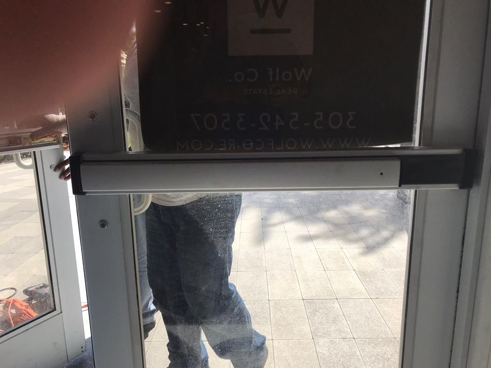 Overhead door closer arm on an aluminum storefront door